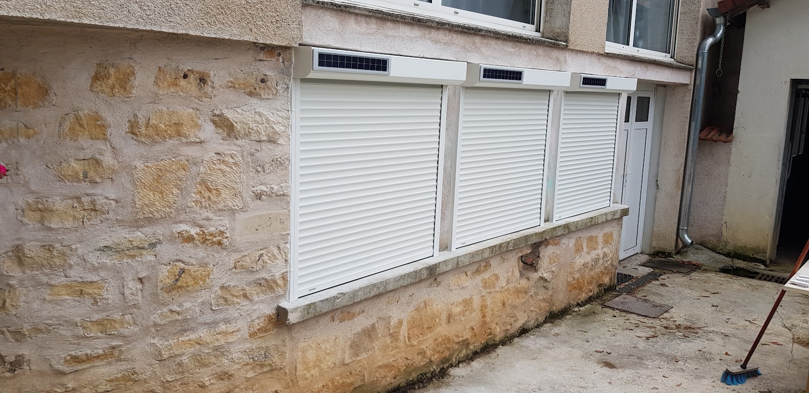 Pose de volets roulants solaires sur façade en pierre