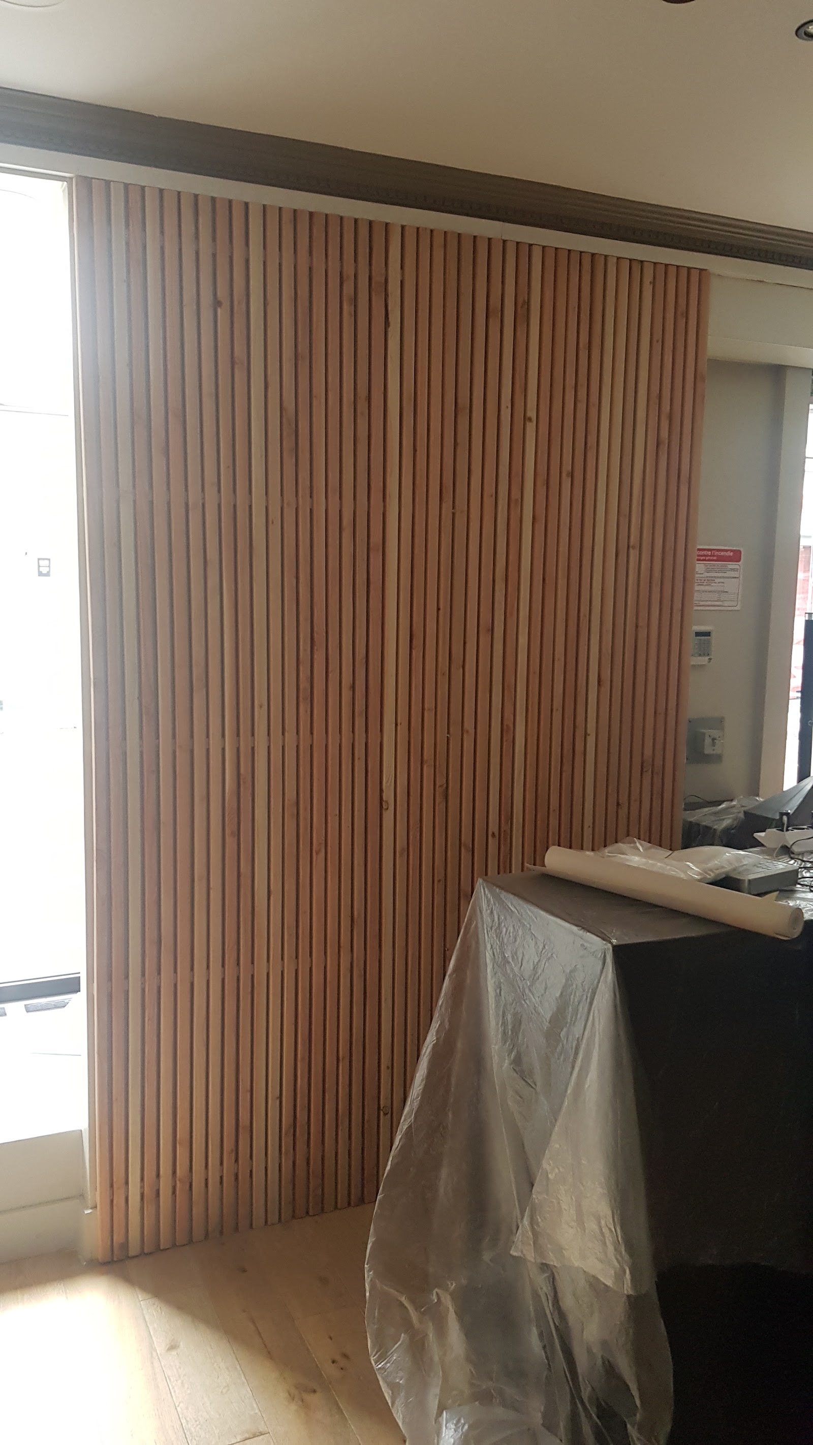 Habillage mural en tasseaux de bois clair